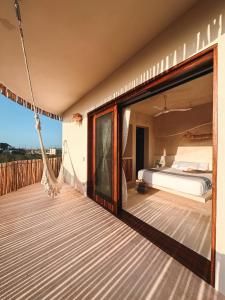 a bedroom with a bed and a hammock on a deck at Casa Noma-Noma Holbox in Holbox Island