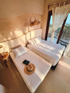 a hotel room with two beds with a hat on it at Casa Noma-Noma Holbox in Holbox Island