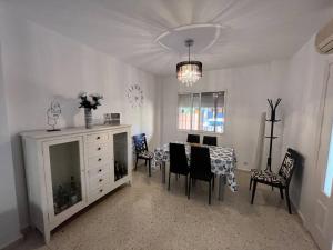 Casa Luz y Azahar في سان خوان ديل بويرتو: غرفة معيشة مع طاولة طعام وكراسي