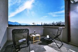 a balcony with two chairs and a table with a view at Dubrovnik Airport Apartment Tea in Durovići