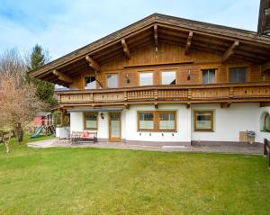 a large wooden house with a large yard at Ferienwohnung Stock in Kirchdorf in Tirol