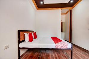 a bedroom with a bed with red pillows at OYO Pine Tree in Mussoorie