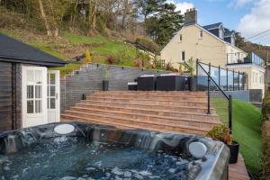 uma banheira de hidromassagem no quintal de uma casa em Edith Villas - Luxury seaside home with beautiful sea views-Pendine em Pendine