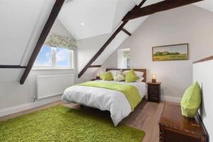um quarto com uma cama verde e um tapete verde em Edith Villas - Luxury seaside home with beautiful sea views-Pendine em Pendine