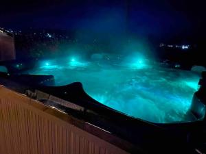 a swimming pool at night with lights in it at Pendine Sands Edith Villas - a luxury seaside home with beautiful sea views in Pendine