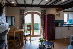 a kitchen with a table and a large window at Gill Cottage, Castle Carrock, Nr Carlisle in Castle Carrock +10 photos