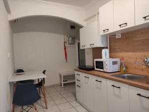 cocina con armarios blancos, fregadero y microondas en Bristol Apartments 2, en Baja
