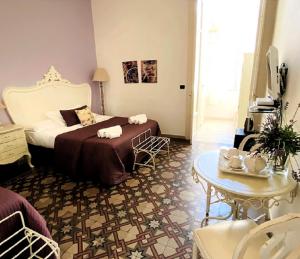 レッジョ・ディ・カラブリアにあるCasa Blancaのベッドとテーブルが備わるホテルルームです。