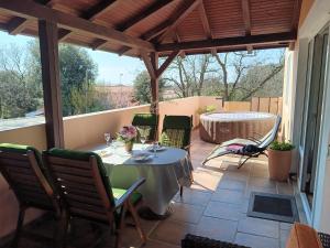 eine Terrasse mit einem Tisch und Stühlen auf einer Veranda in der Unterkunft Apartment Simona - Extra comfort with large terrace and jacuzzi in Barbariga