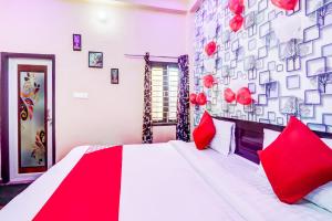 a bedroom with a large bed with red pillows at OYO Flagship Radhey Krishna Bhawan in Bijnaur