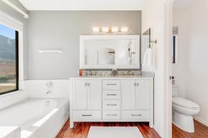 a white bathroom with a tub and a sink and a toilet at Laurel Wood in Oro Valley +43 photos