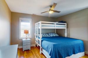 a bedroom with a white bunk bed and a window at Carolina Haven in Topsail Beach