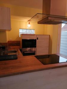 a kitchen with a television and a stove top oven at La longére fleurie in Cucq +9 photos