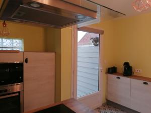 a kitchen with a door leading to a window at La longére fleurie in Cucq