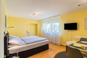 a bedroom with a bed and a desk and a tv at Ferienwohnung Gernsbach in Gernsbach