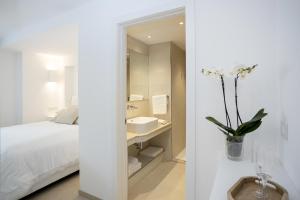 a white bedroom with a sink and a mirror at Pagoda Lifestyle Hotel in Ischia