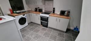 a small kitchen with a washer and dryer in it at Warwick St by Prestige Properties SA in Barrow in Furness