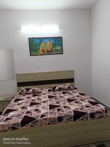 メーラトにあるOYO Hotel Maharajaの壁に絵が描かれたベッドルームのベッド1台