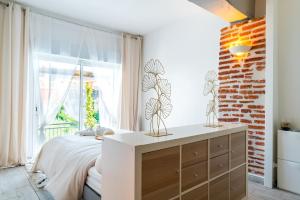 - une chambre avec un lit et un mur en briques dans l'établissement Maison de vacances, VillaNueva, pour 6 personnes à 5min du centre-ville, à Villeneuve-sur-Lot