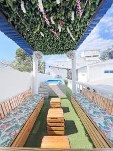 a row of benches on a patio with flowers at Comunidad Calle 13 Hotel Boutique in Santa Marta