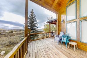 a porch with two chairs and a table on it at Joining Families at Bear Lake in Garden City