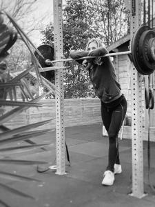 Una mujer está haciendo sentadillas en un gimnasio en La Wodapalousa, Surf & Crossfit Guesthouse, 800m from Beach, en Bidart