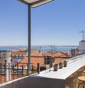 a balcony with a view of the ocean and buildings at Amazing Rooftop Terrace With River And Historic City View 4 Bedrooms 4 bathrooms AC 19th Century Building Chiado in Lisbon