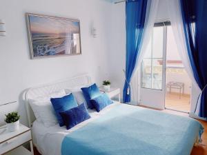 a bedroom with a large bed with blue pillows at Beach House Casa Dolce in Benagil in Benagil