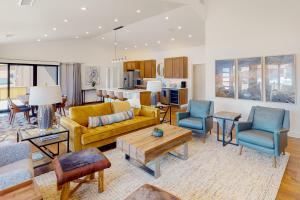 a living room with a yellow couch and blue chairs at Leisure Lodge Living in Gunnison