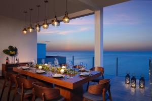 a dining room with a table and chairs with a view of the ocean at Dreams Cozumel Cape Resort & Spa in Cozumel