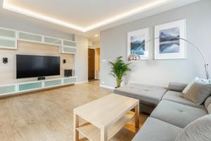 een woonkamer met een bank en een flatscreen-tv bij 2 sypialnie + salon nowe osiedle J. Kazimierza in Warschau
