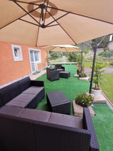 un patio con sofás, mesas y una sombrilla en Prenájom v súkromí Krompachy en Krompachy