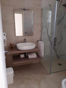 y baño con lavabo y ducha acristalada. en Masseria Pozzelle, en Otranto