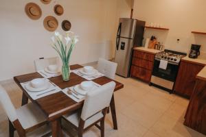 a kitchen with a wooden table with chairs and a dining room at Lahos Apartament's in Panajachel