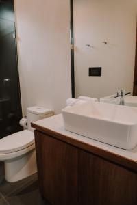 a bathroom with a white sink and a toilet at Lahos Apartament's in Panajachel