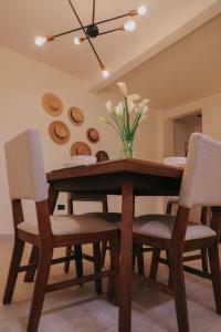 a dining room table with chairs and a vase of flowers at Lahos Apartament's in Panajachel