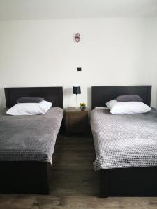 a bedroom with two beds and a table with a lamp at MAWAROOMS in Świeradów-Zdrój