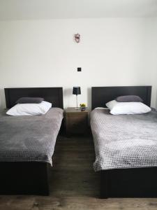 sypialnia z 2 łóżkami i stołem z lampką w obiekcie MAWAROOMS w Świeradowie Zdroju