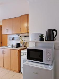 a kitchen with a microwave sitting on top of a stove at Alta apartments in Coimbra