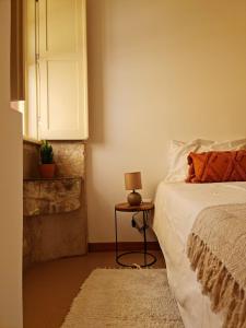 a bedroom with a bed and a table with a lamp at Alta apartments in Coimbra
