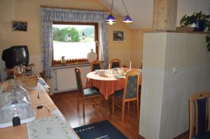 ein Esszimmer mit einem Tisch, Stühlen und einem Fenster in der Unterkunft Pension Jonas in Baar