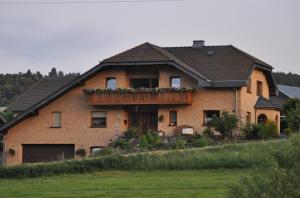 ein großes Backsteinhaus mit Balkon darauf in der Unterkunft Pension Jonas in Baar