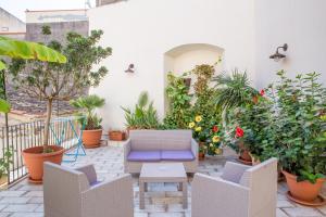 Casa dell'Aromatario b&b في شاكا: فناء به نباتات الفخار وكرسي أزرق