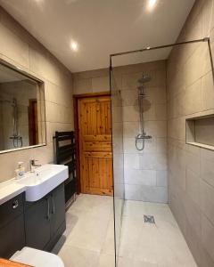 a bathroom with a sink and a glass shower at Countryside Log Cabin With Hot Tub - Beech in Leominster