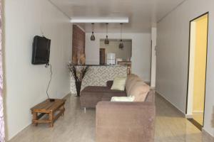 een woonkamer met een bank en een tv bij Casa da Sueli in Foz do Iguaçu