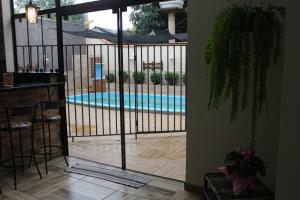 een uitzicht op een zwembad door een glazen schuifdeur bij Casa da Sueli in Foz do Iguaçu