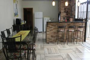 een keuken met een tafel, stoelen en een koelkast bij Casa da Sueli in Foz do Iguaçu