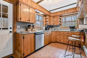 a kitchen with wooden cabinets and a white door at Woodland Cabin Retreat in Lake Harmony