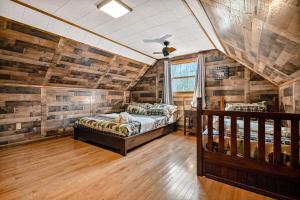 a bedroom with two beds in a room with wooden walls at Woodland Cabin Retreat in Lake Harmony