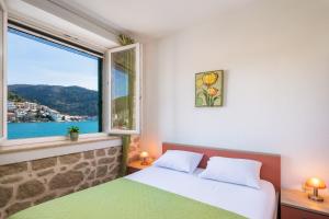 a bedroom with a bed and a large window at Adriatic Sunrise - Beach House in Blace